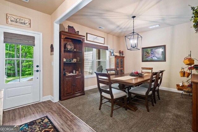 dining room with an inviting chandelier, baseboards, dark wood-style flooring, and visible vents
