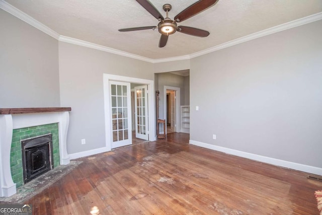 unfurnished living room with ornamental molding, wood finished floors, baseboards, ceiling fan, and french doors