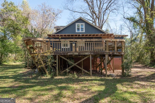 rear view of property featuring a lawn and a wooden deck