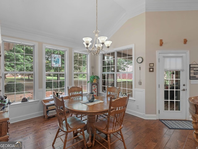 dining room featuring lofted ceiling, a wainscoted wall, dark wood-type flooring, an inviting chandelier, and crown molding