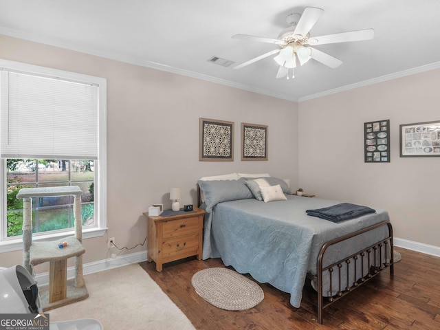 bedroom with crown molding, visible vents, wood finished floors, and baseboards