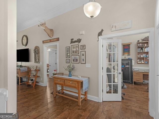 corridor with wood finished floors, baseboards, and ornamental molding