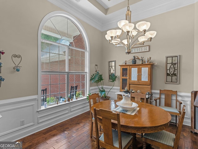 dining space with crown molding, a chandelier, wainscoting, and wood-type flooring