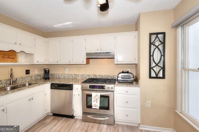 3716 Meeting St, Duluth, GA 30096 - kitchen featuring a sink, under cabinet range hood, light wood-style flooring, white cabinets, and appliances with stainless steel finishes