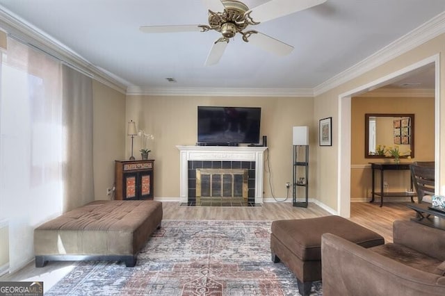 3716 Meeting St, Duluth, GA 30096 - living area featuring a ceiling fan, baseboards, a tiled fireplace, crown molding, and wood finished floors