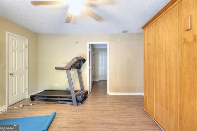 3716 Meeting St, Duluth, GA 30096 - workout area featuring a textured ceiling, baseboards, a ceiling fan, and wood finished floors