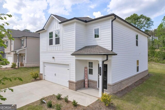 828 Evergreen Rd, Winder, GA 30680 - view of front of property with a garage, board and batten siding, driveway, and a front lawn