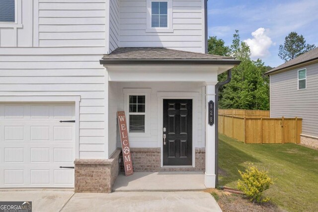 828 Evergreen Rd, Winder, GA 30680 - property entrance with fence, roof with shingles, brick siding, a garage, and a yard