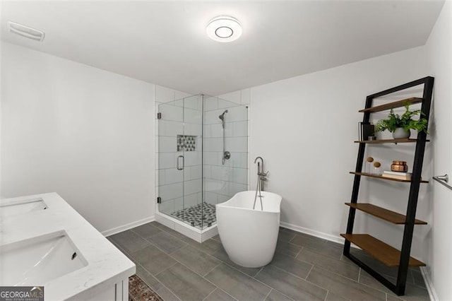 800 Breckinridge Rd SW, Marietta, GA 30064 - bathroom featuring a freestanding bath, a sink, double vanity, baseboards, and a stall shower