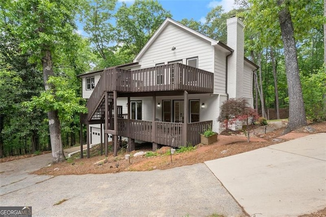 800 Breckinridge Rd SW, Marietta, GA 30064 - exterior space featuring driveway, a chimney, a deck, stairway, and an attached garage