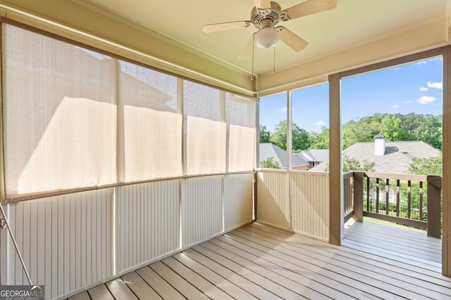 unfurnished sunroom with ceiling fan