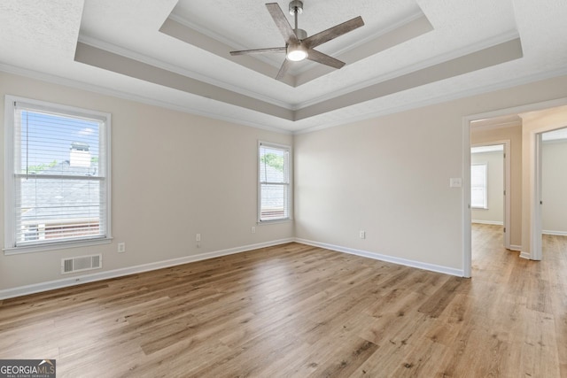 unfurnished room with visible vents, crown molding, and a tray ceiling