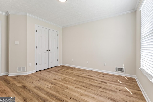 unfurnished bedroom featuring baseboards, light wood finished floors, and visible vents