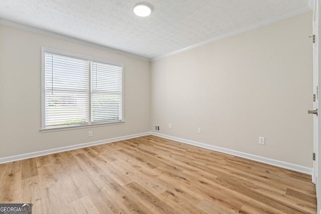 empty room featuring visible vents, ornamental molding, baseboards, a textured ceiling, and light wood finished floors