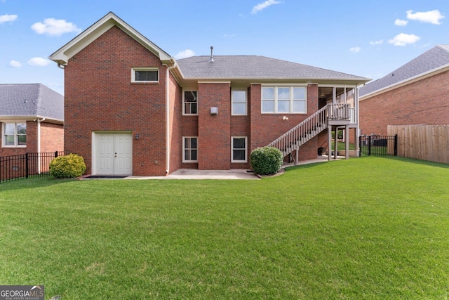 back of property with a yard, brick siding, a patio, and a fenced backyard
