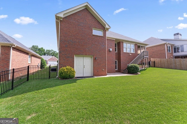rear view of house featuring brick siding, a fenced backyard, a patio area, and a yard