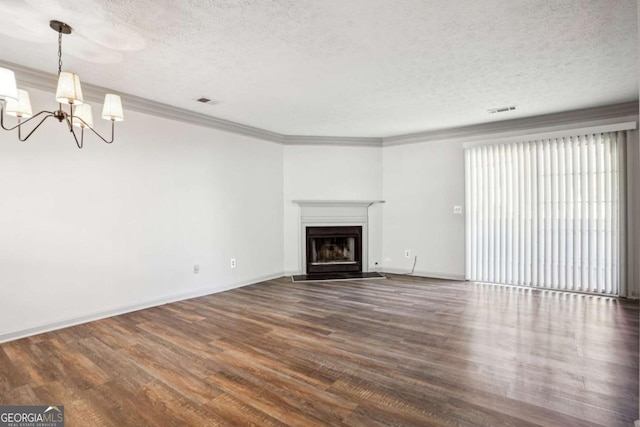 2047 Charter Ln, Lithonia, GA 30058 - unfurnished living room with a chandelier, a textured ceiling, dark wood finished floors, a fireplace with flush hearth, and crown molding