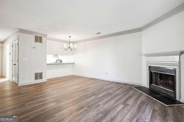 2047 Charter Ln, Lithonia, GA 30058 - unfurnished living room featuring ornamental molding, a chandelier, wood finished floors, a fireplace with raised hearth, and a textured ceiling