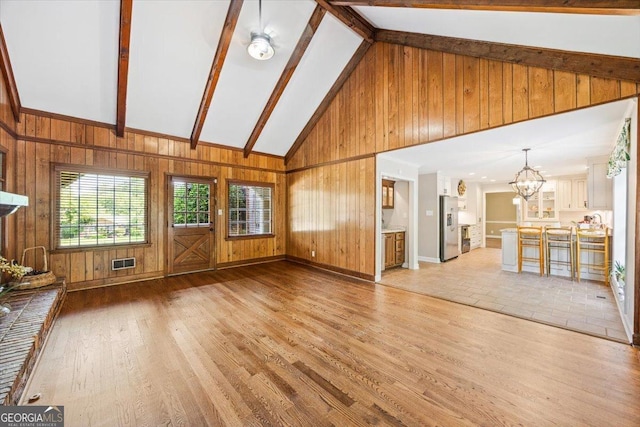 4802 Wesleyan Woods Dr, Macon, GA 31210 - unfurnished living room with wooden walls, an inviting chandelier, visible vents, and light wood-type flooring