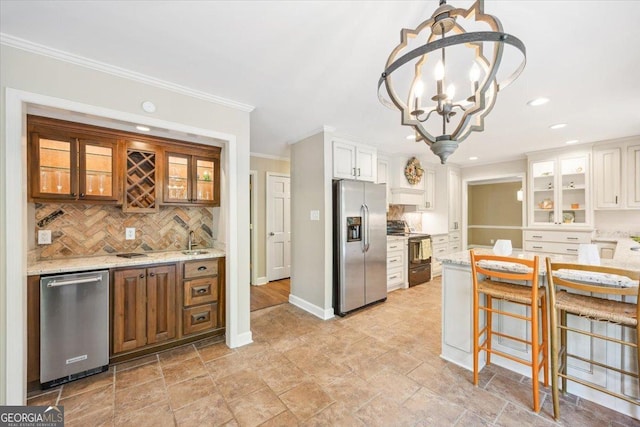 4802 Wesleyan Woods Dr, Macon, GA 31210 - kitchen with decorative backsplash, light stone countertops, glass insert cabinets, appliances with stainless steel finishes, and a notable chandelier