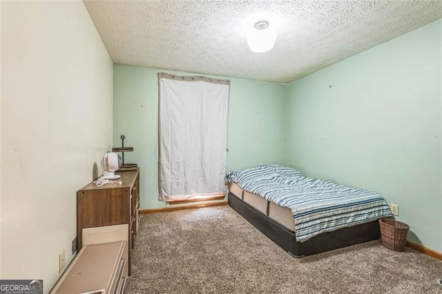 bedroom featuring baseboards, carpet flooring, and a textured ceiling