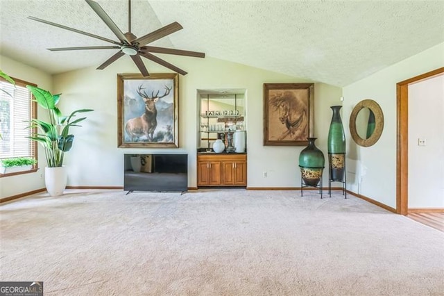 sitting room featuring a ceiling fan, a textured ceiling, lofted ceiling, and carpet flooring
