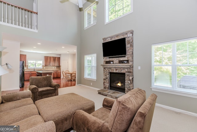 674 Chadmon Court Trce, Dacula, GA 30019 - carpeted living area featuring a towering ceiling, healthy amount of natural light, a ceiling fan, and a stone fireplace