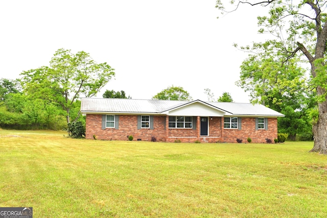 single story home featuring brick siding, metal roof, and a front yard