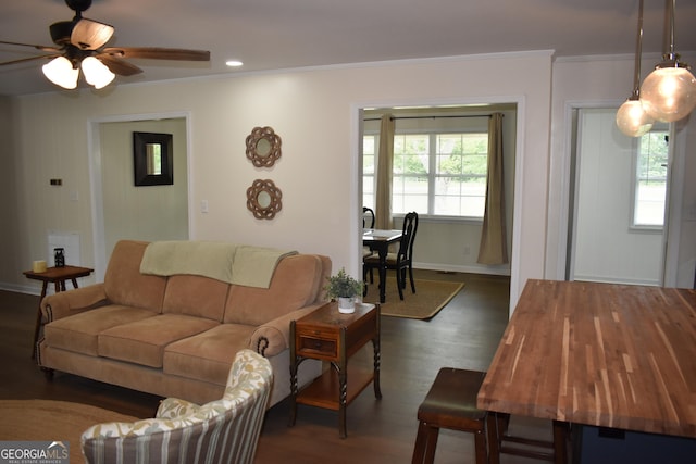 living room with baseboards, ornamental molding, dark wood finished floors, and a ceiling fan