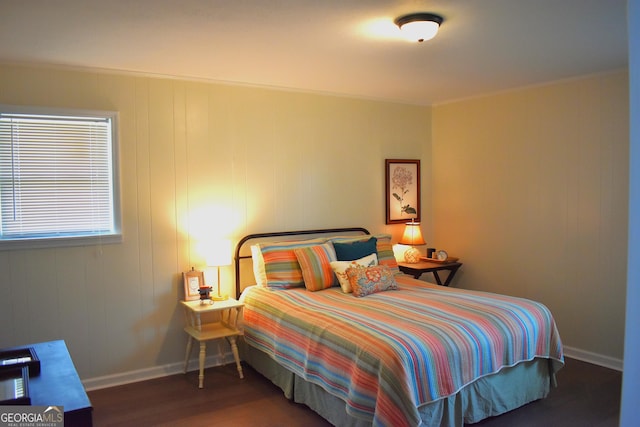 bedroom with baseboards, ornamental molding, and wood finished floors