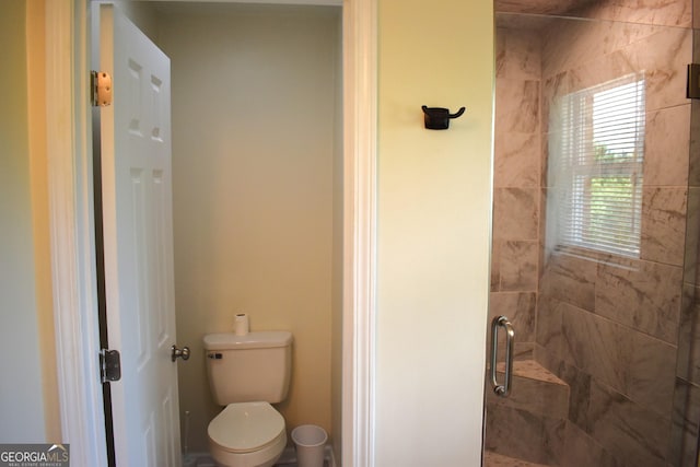 bathroom featuring toilet and a shower stall