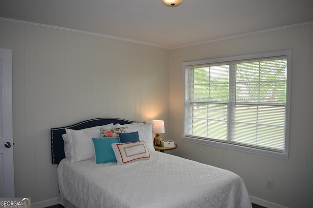 bedroom with crown molding, baseboards, and multiple windows