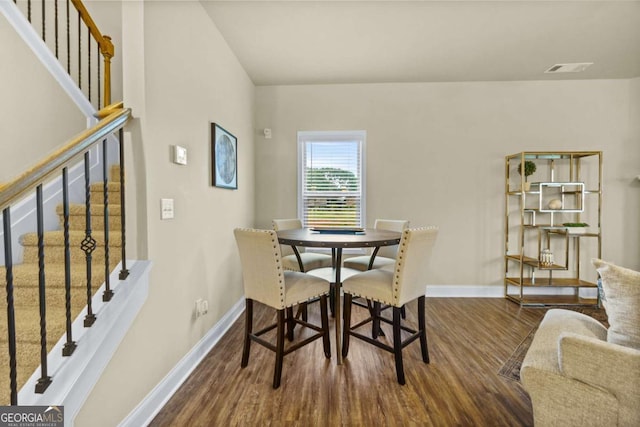 dining area featuring baseboards, stairs, and wood finished floors