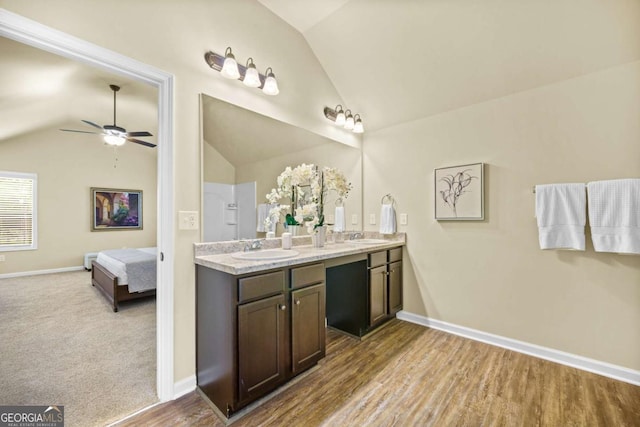 full bathroom with a sink, ensuite bath, and vaulted ceiling