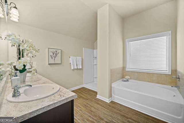 bathroom featuring vanity, baseboards, a garden tub, and wood finished floors