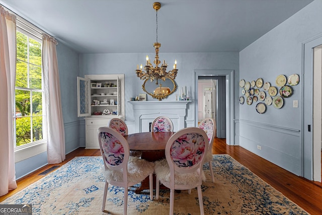 dining area featuring visible vents, wood finished floors, a notable chandelier, and a wealth of natural light