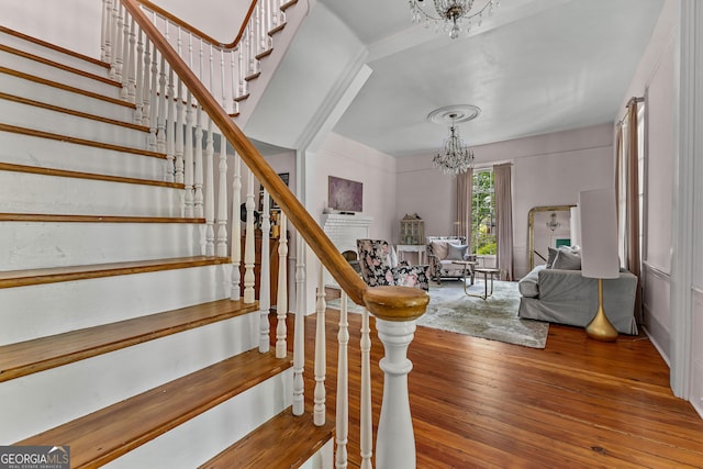 stairs with a notable chandelier and hardwood / wood-style flooring