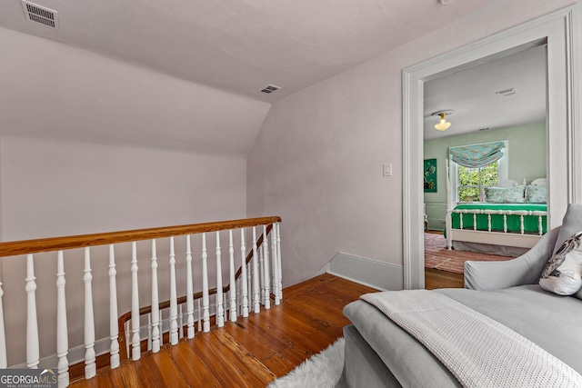 bedroom with baseboards, hardwood / wood-style flooring, and visible vents