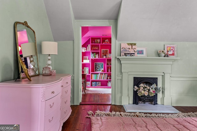 bedroom with a fireplace with raised hearth and hardwood / wood-style flooring
