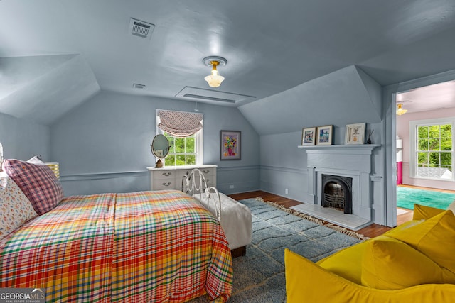 bedroom with visible vents, wood finished floors, and vaulted ceiling