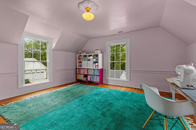 interior space featuring plenty of natural light, wood finished floors, and lofted ceiling