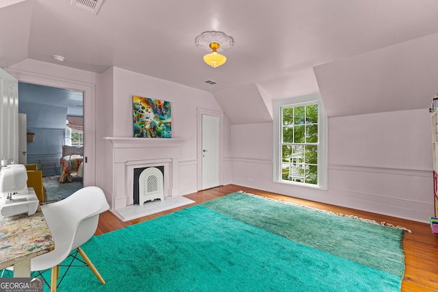 living area featuring visible vents, wood finished floors, and lofted ceiling