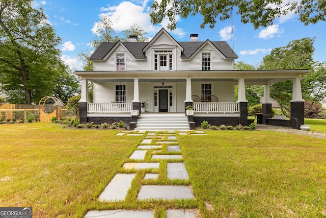 view of front of house featuring fence, a chimney, a porch, and a front lawn