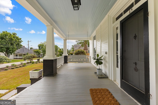 wooden terrace with a porch and a yard