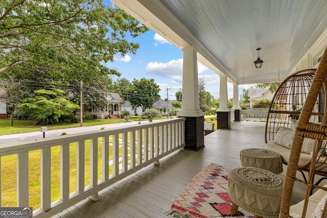 wooden deck featuring a porch and a yard