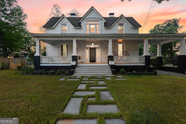 view of front of house with a lawn and a porch