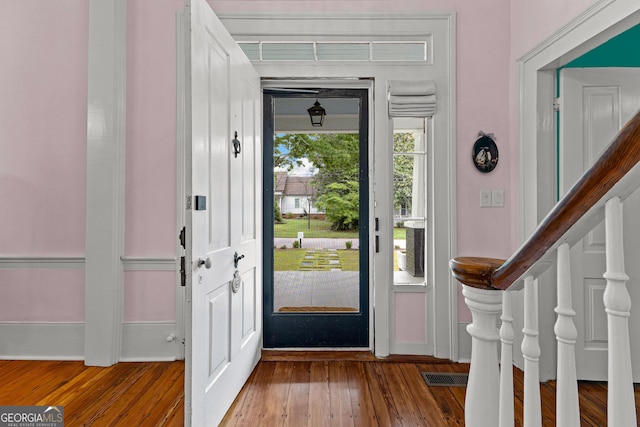foyer with baseboards and hardwood / wood-style floors