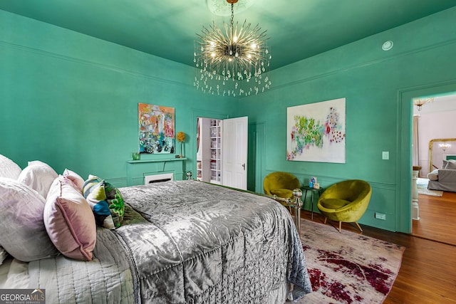 bedroom with wood finished floors and a notable chandelier