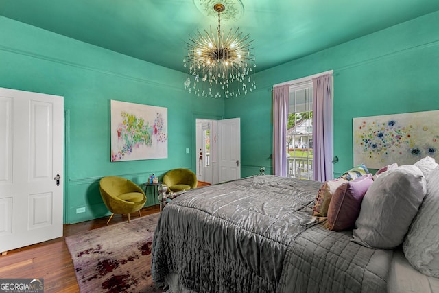 bedroom featuring an inviting chandelier and wood finished floors