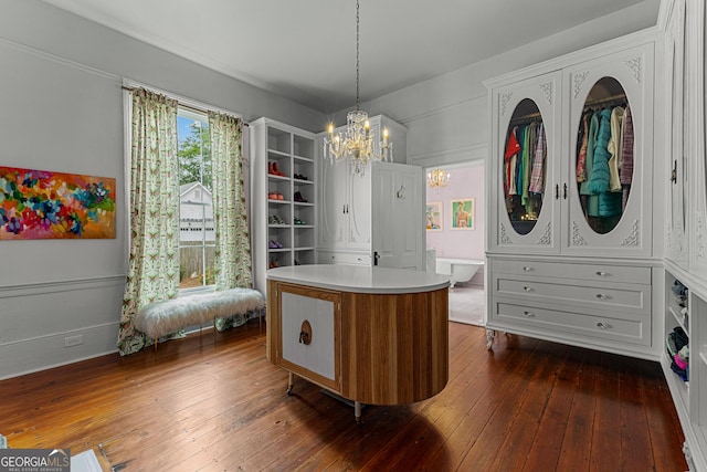 walk in closet featuring an inviting chandelier and dark wood-style flooring